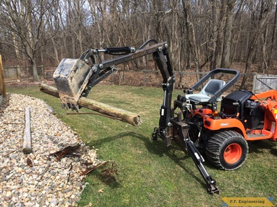 Kubota BX2200 micro hoe picking up log with thumb by Mark J.